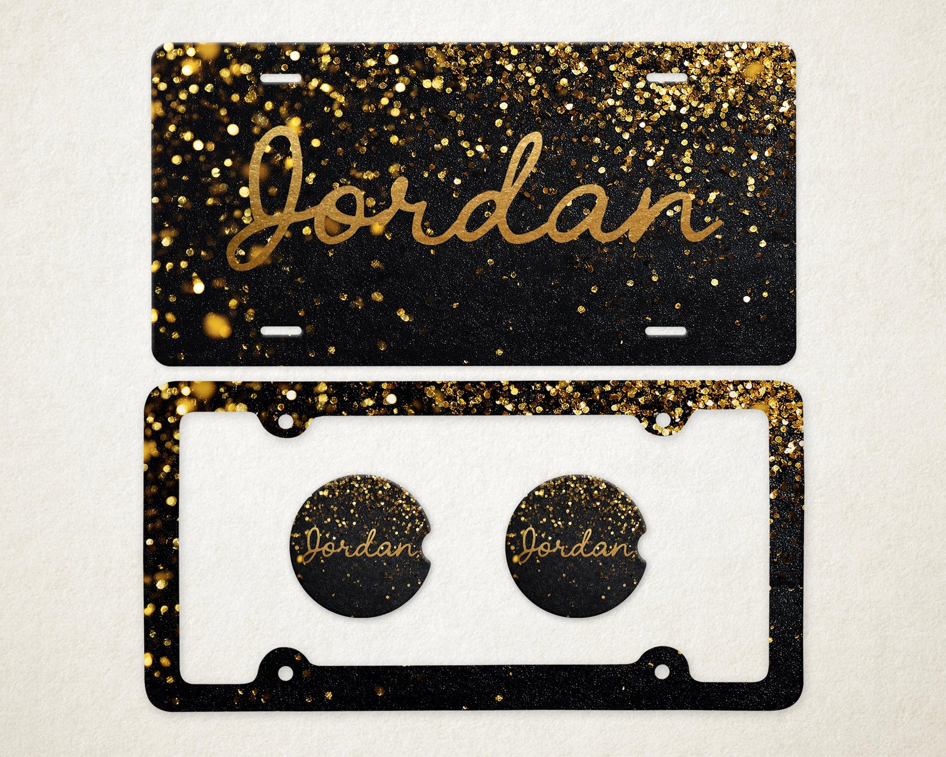 May include: A black license plate and car coaster set with gold glitter and the name "Jordan" in gold script. The license plate has a black background with gold glitter. The car coasters have the name "Jordan" in gold script.